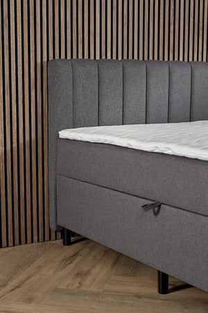 Antraciet boxspring Comfort by Bedden.nl with built-in storage, showing the upholstered bed with storage drawers underneath.