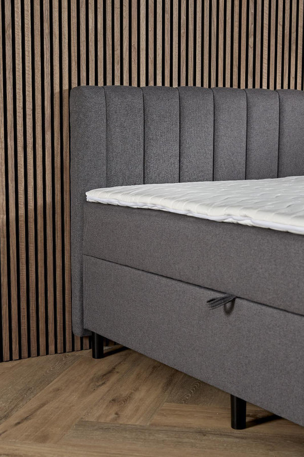 Antraciet boxspring Comfort by Bedden.nl with built-in storage, showing the upholstered bed with storage drawers underneath.