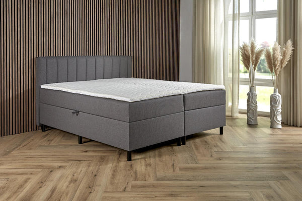Antraciet Boxspring Comfort with built-in storage, featuring a padded headboard and sleek design from Bedden.nl.
