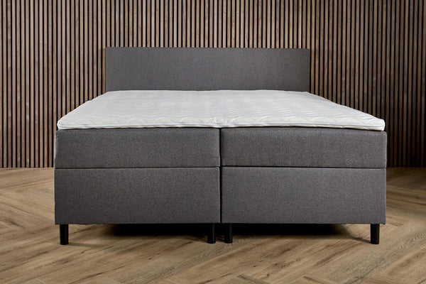 Boxspring Essential bed with built-in storage, basic and comfortable, from Bedden.nl, shown with the mattress and storage compartments visible.