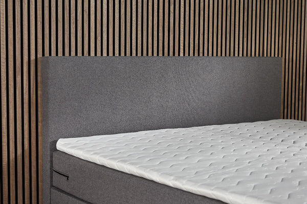 Boxspring Essential bed with built-in storage, basic and comfortable, featuring a sturdy frame and plush bedding from Bedden.nl.